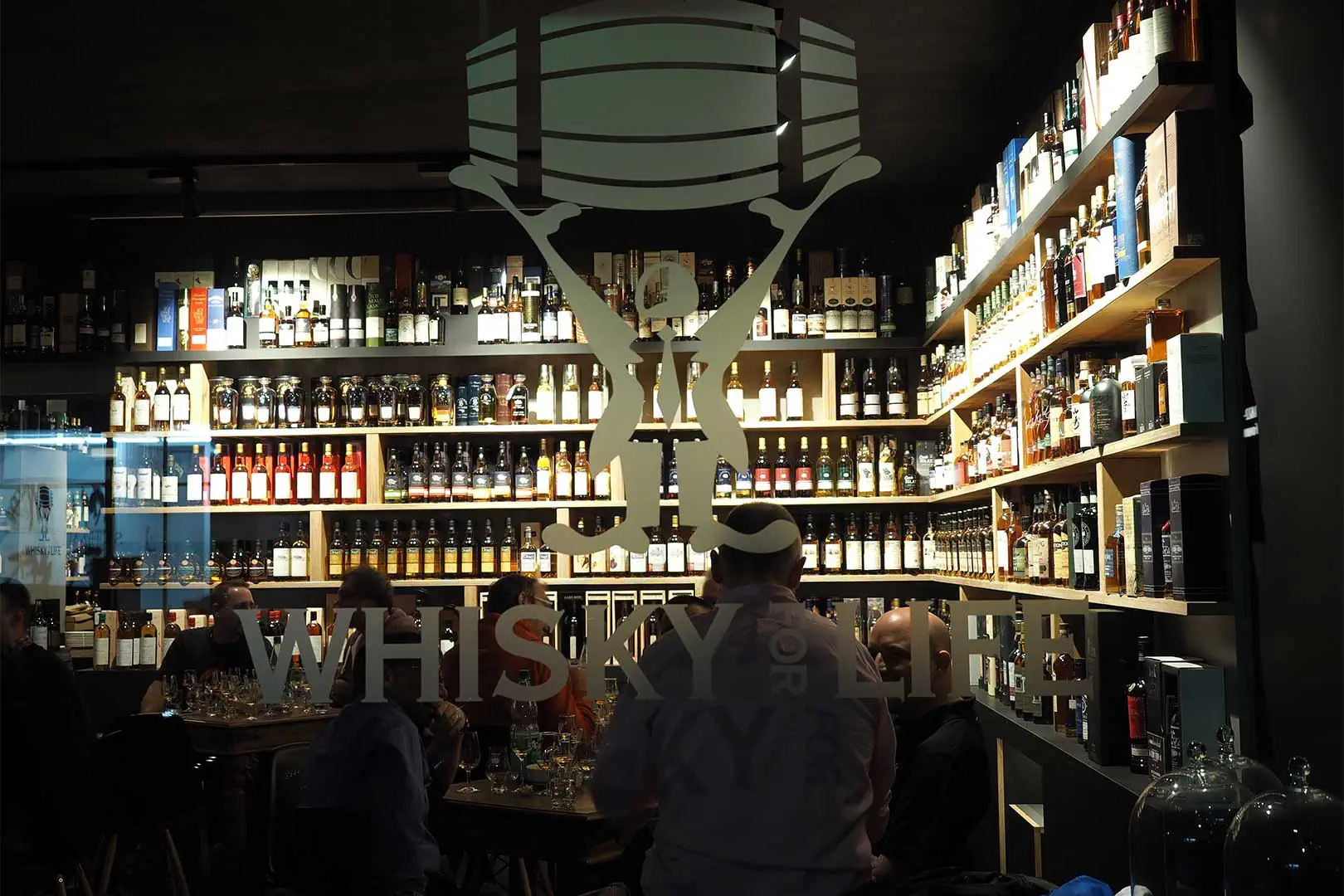 Tasting-Abend im Whisky For Life – Gäste verkosten Whiskies umgeben von hunderten Flaschen